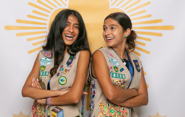 ambassador high school girl scout wearing sash outside against green background