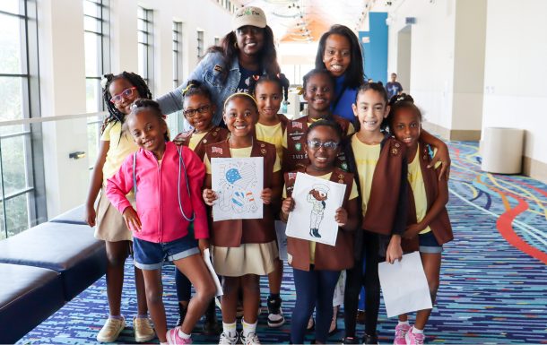two adult leaders with a troop of Brownie girls at a Girl Scout event
